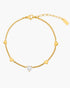 Gold bracelet with heart-shaped diamond on a white background